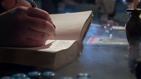 The witch is reading a magic book. Makes notes of a ritual ceremony. Conducts a Stock Footage 125738890