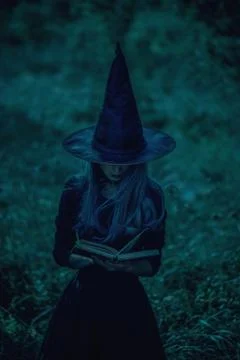 Witch reading a magic book Stock Photos