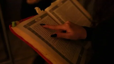 The witch runs her finger over the book video footage Stock Footage