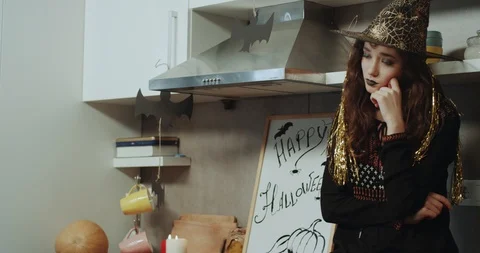 A witch with a sad face have bad mood on Halloween night , sitting on the Stock Footage 96518038