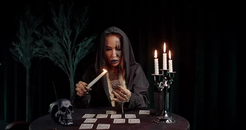 Witch selecting tarot card during dark ritual Video stock 319601336