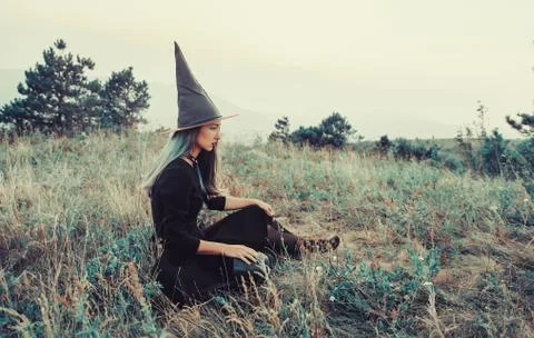 Witch sitting on meadow Stock Photos