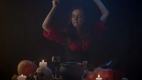 Witch at table in dark with steaming cauldron Stock Footage 141294277