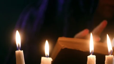 Witch telling spell from old book under candles. Halloween concept. Stock Footage 123668552