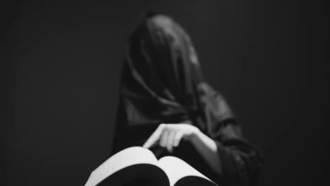 A witch turning pages of the book to perform magic Stock Footage 258987774