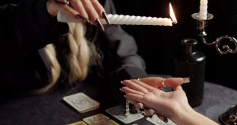 Witch using burning candle in mystical palm reading ritual Stock Footage 320007295