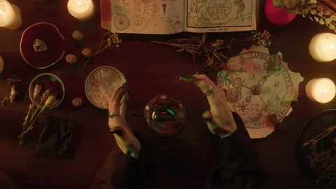Witch using magic crystal ball top view. Table with spellbook for making rite Stock Footage 161335498