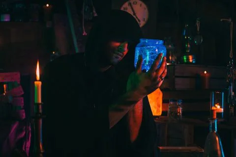 Witcher alchemist makes a secret potion in gloomy laboratory workshop. Magician Stock Photos
