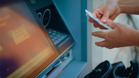 Withdrawing cash from automated teller machine and counting banknotes after Stock Footage 338069601