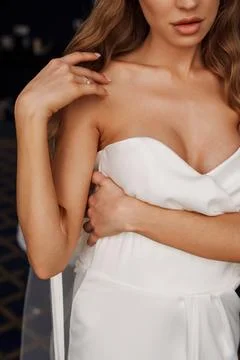 Without a face. The bride is wearing a white wedding dress with open shoulders. Stock Photos