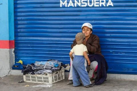 Witness a heartwarming moment as a street vendor woman dotes on her little boy a Stock Photos
