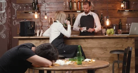 Witress tries to wake a drunk customer that got sick Stock Footage 104867937
