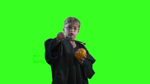 A wizard boy with a magic wand in a Halloween costume on green background Stock Footage 284473287