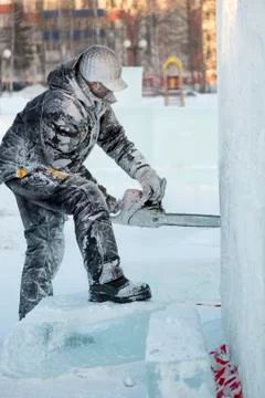The wizard cuts figures from the ice chainsaw 스톡 사진