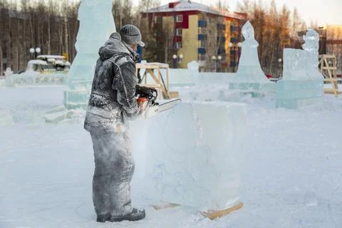 The wizard cuts figures from the ice chainsaw Fotos Stock