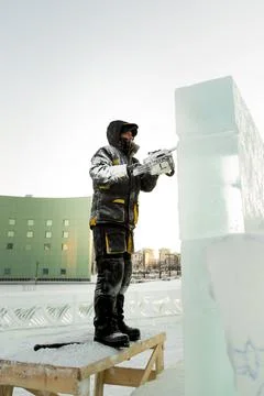 The wizard cuts figures from the ice chainsaw 스톡 사진