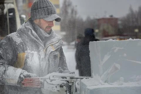 The wizard cuts figures from the ice chainsaw 스톡 사진