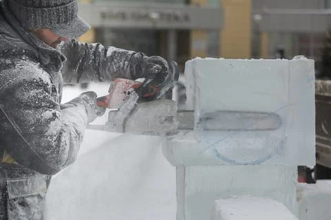 The wizard cuts figures from the ice chainsaw 스톡 사진