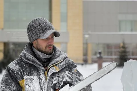 The wizard cuts figures from the ice chainsaw 스톡 사진