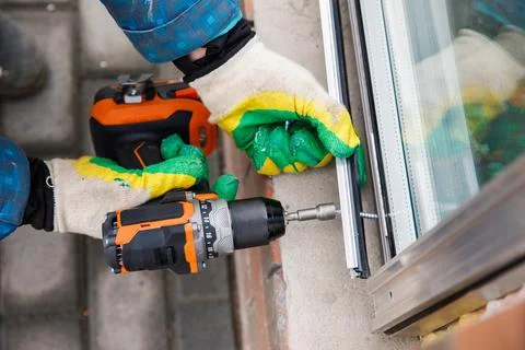 The wizard is engaged in installing windows. Repair work. Stock Photos