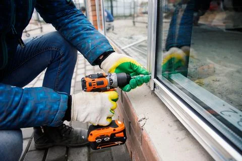 The wizard is engaged in installing windows. Repair work. Stock Photos