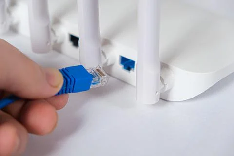 The wizard inserts the Internet cable into the Wi-Fi router. Internet connection Stock Photos
