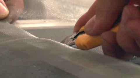 The wizard inserts the mosquito net in the frame for the window Stock Footage 75156927