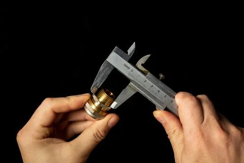 The wizard measures the size of brass fitting using a caliper Stock Photos