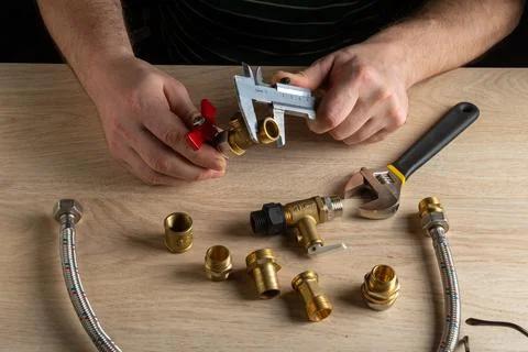 The wizard measures the size of fitting using a caliper before connecting Stock Photos