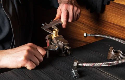 The wizard measures the size of fitting using a caliper before connecting Stock Photos