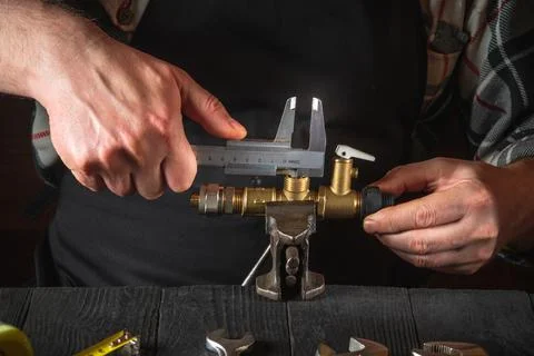 The wizard measures the size of fitting using a caliper before connecting Stock Photos