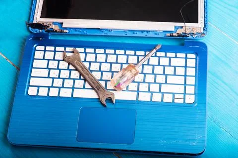 Wizard repairs laptop with tools and hands on the blue wooding table. top v.. Stock Photos