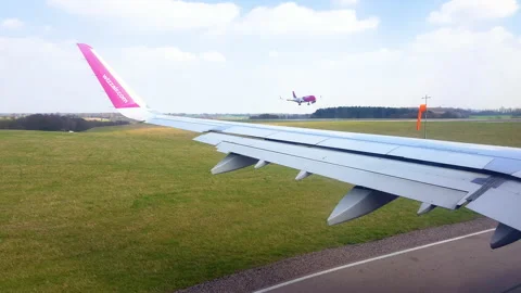 Wizzair plane approaches the runway while another plane lands. Stock Footage 131753086