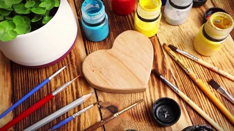 Wodden heart in the middle with different colors gouache and brushes Stock Footage 295126003