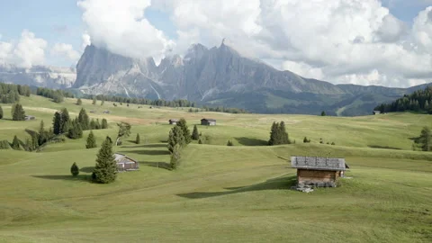 Woden mountain huts and rolling alpine meadows at Seiser Alm plateau Stock Footage 150411327