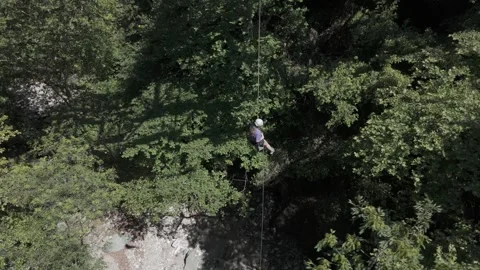 Woiman rappeling into a forest river Stock Footage 288738904