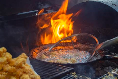 Wok on fire in a mobile kitchen. Stock Photos
