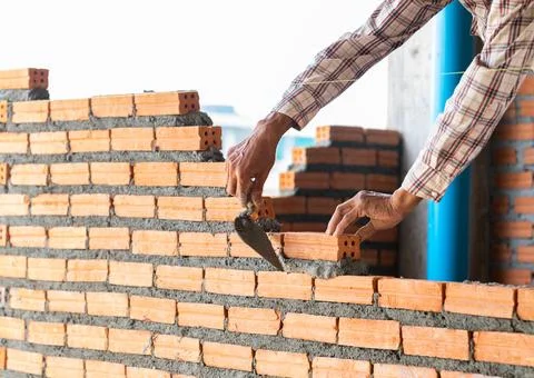 Woker manson stack brick of wall bathroom in building site. Stock-Fotos