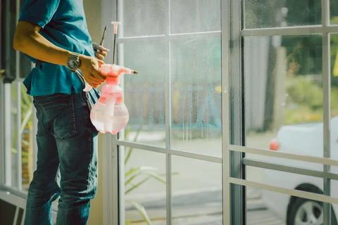 Woker wrapper tinting a window using foggy spray. Stock Photos