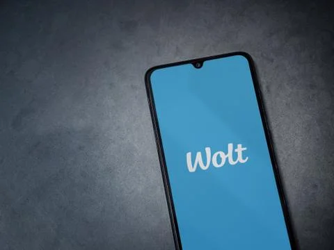 Wolt app launch screen with logo on the display of a black mobile smartphone  Stock Photos