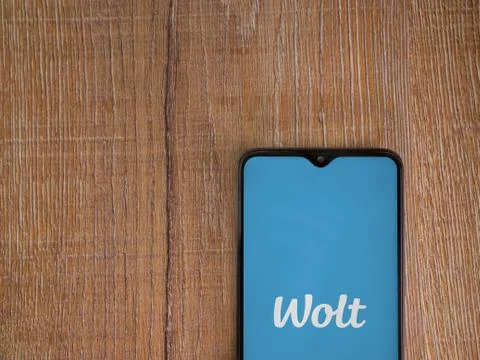 Wolt app launch screen with logo on the display of a black mobile smartphone  Stock Photos