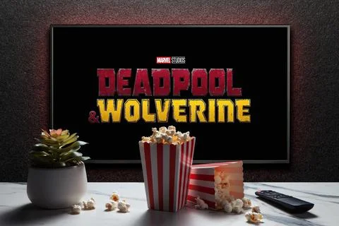 Wolverine and Deadpool trailer or movie on TV screen. TV with remote control Stock Photos