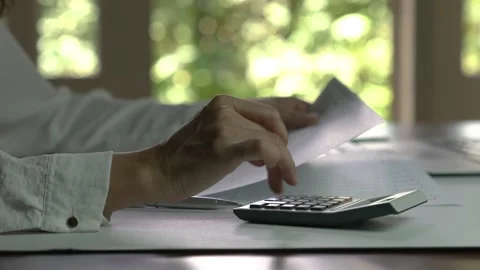 Woman Accountant analyzing data on a document and using the calculator. Stock Footage 147650947