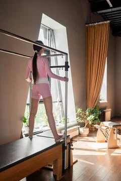 A woman in activewear does Flying Eagle pilates exercises for the chest and Stock Photos