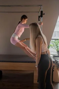 A woman in activewear does Flying Eagle pilates exercises for the chest and Stock Photos
