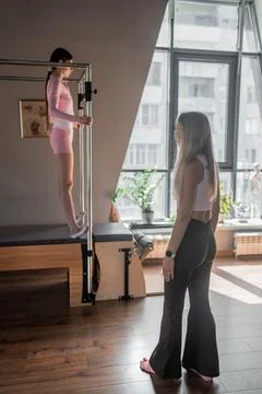 A woman in activewear does Flying Eagle pilates exercises for the chest and Stock Photos