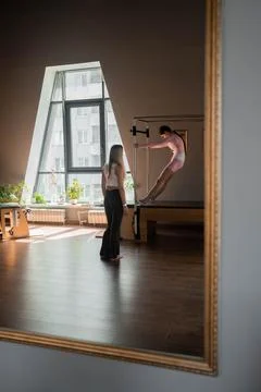 A woman in activewear does Flying Eagle pilates exercises for the chest and Stock Photos