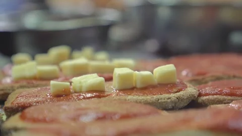 Woman adding cheese over breaded eggplant in a restaurant. Stock Footage 240784847
