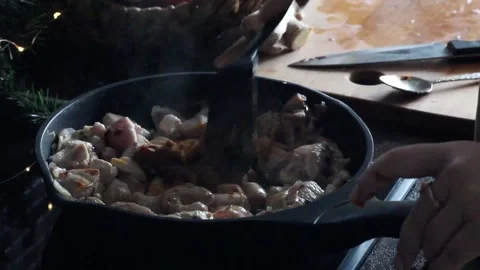 Woman adding curry paste to a frying pan with chicken Stock Footage 137551899