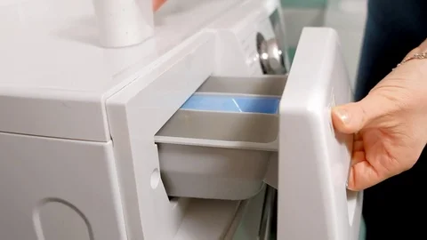 Woman adding detergent to compartment in washing machine and closing drawer Stock Footage 85333201